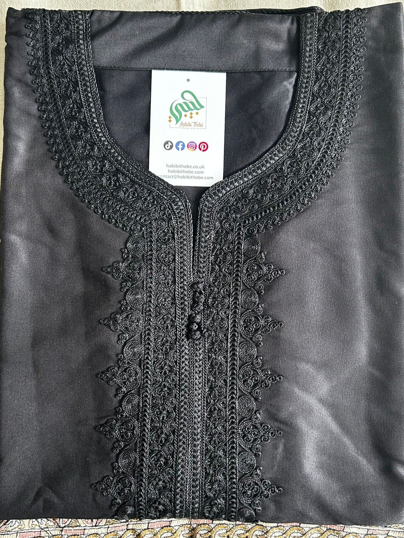 "Black Moroccan Gandoura featuring subtle black-on-black embroidery, side pocket, and opposite side slit for easy access."