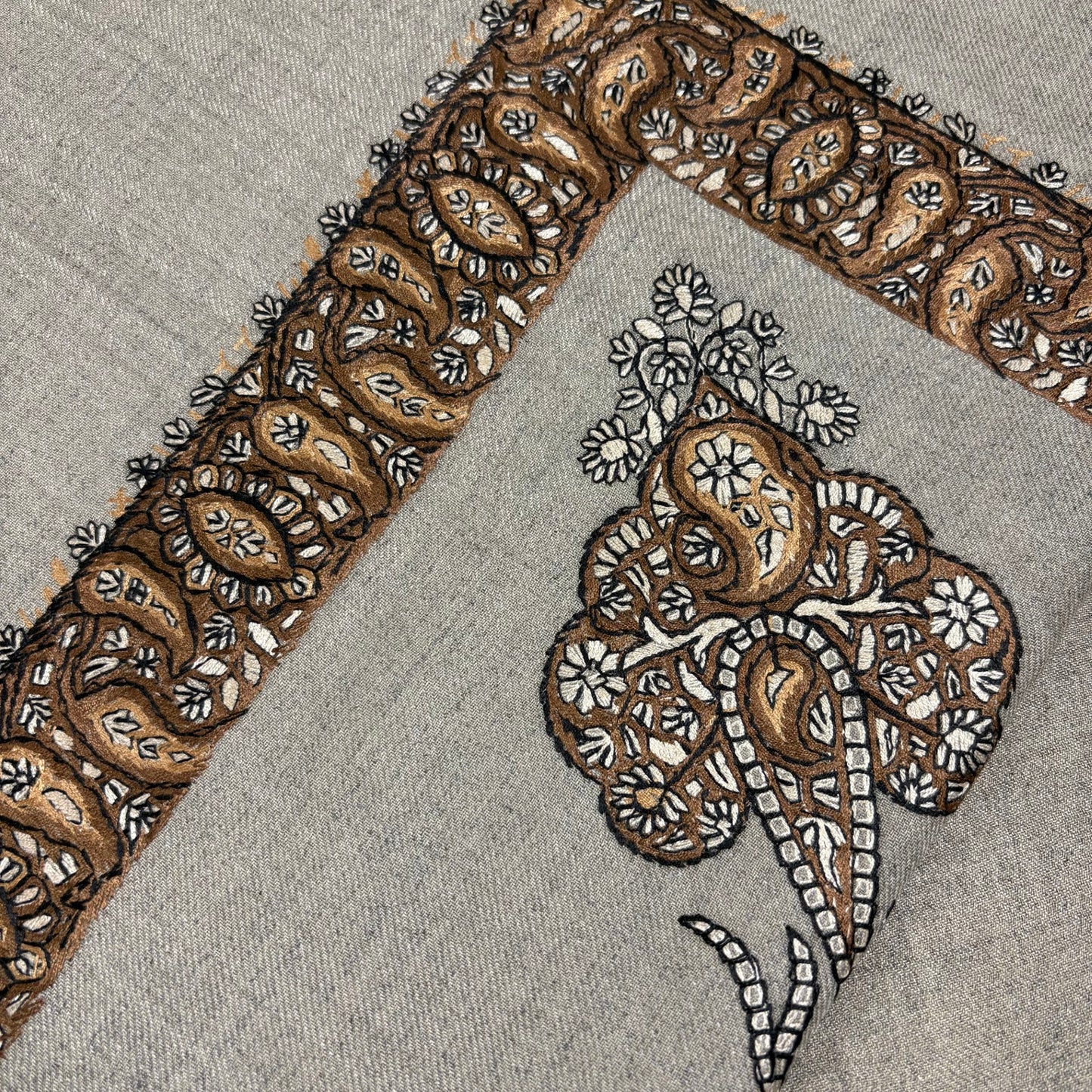 Close-up of intricate brown and beige embroidery on a shemagh