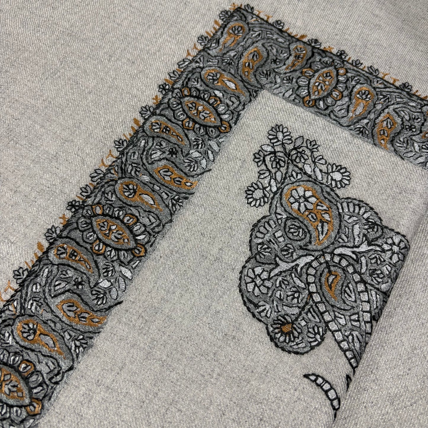 Embroidered fabric with paisley patterns on a gray Shemagh