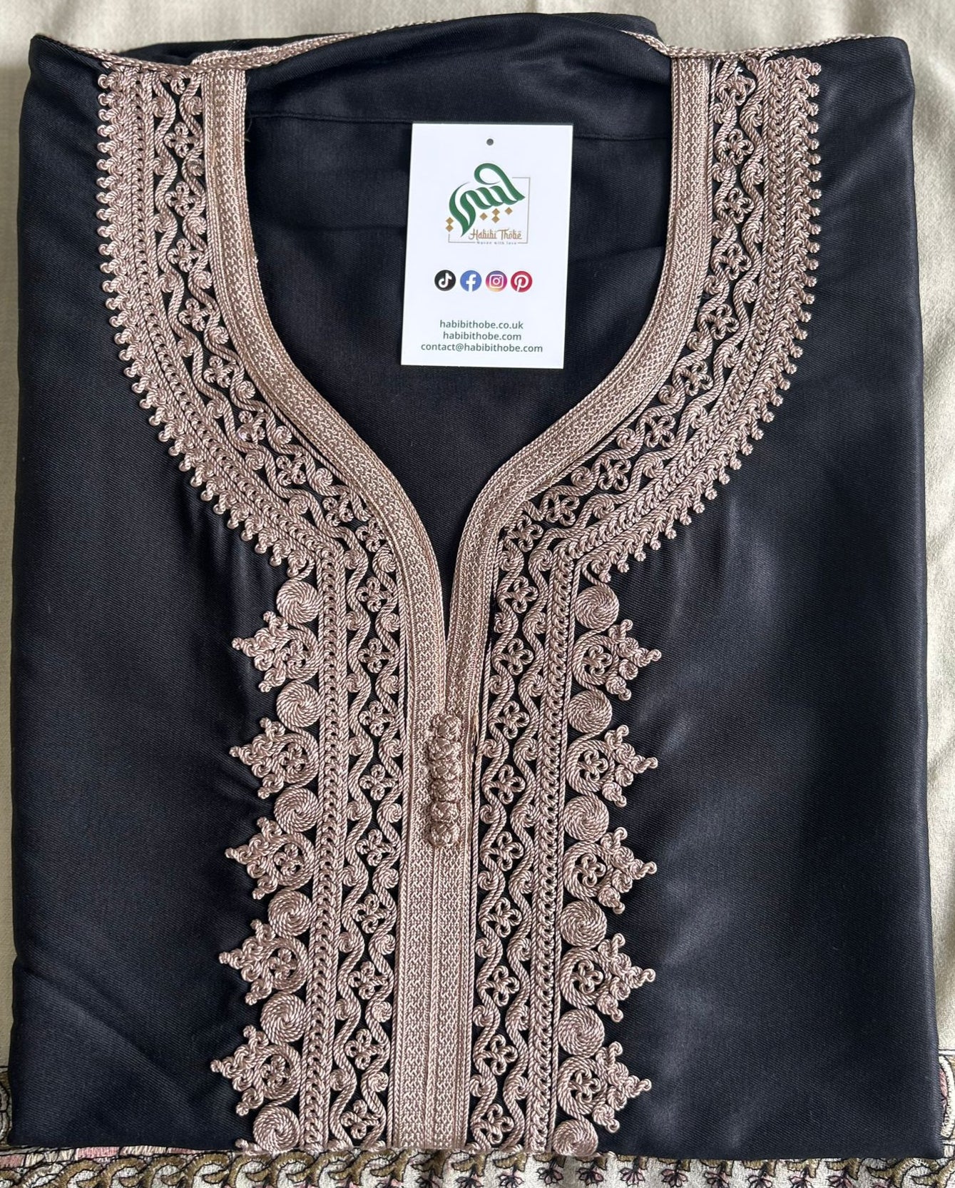 "Black Moroccan Thobe adorned with intricate dusty rose embroidery, featuring a side pocket and opposite side slit for easy access.