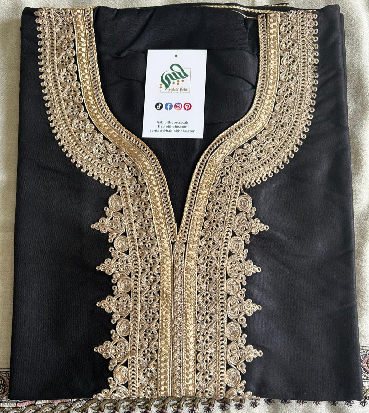 "Black Moroccan Thobe with intricate royal gold embroidery, featuring a side pocket and opposite side slit for easy access."