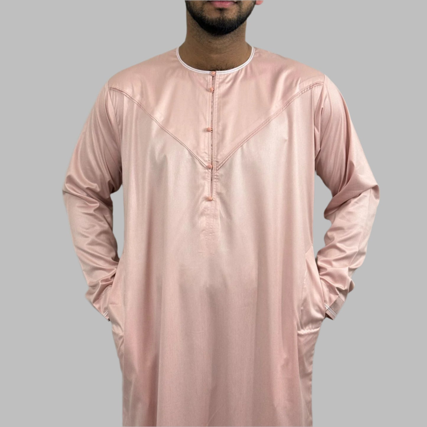 close-up of Al-Majd Thobe’s pink round buttons and boat neck design for a unique look.