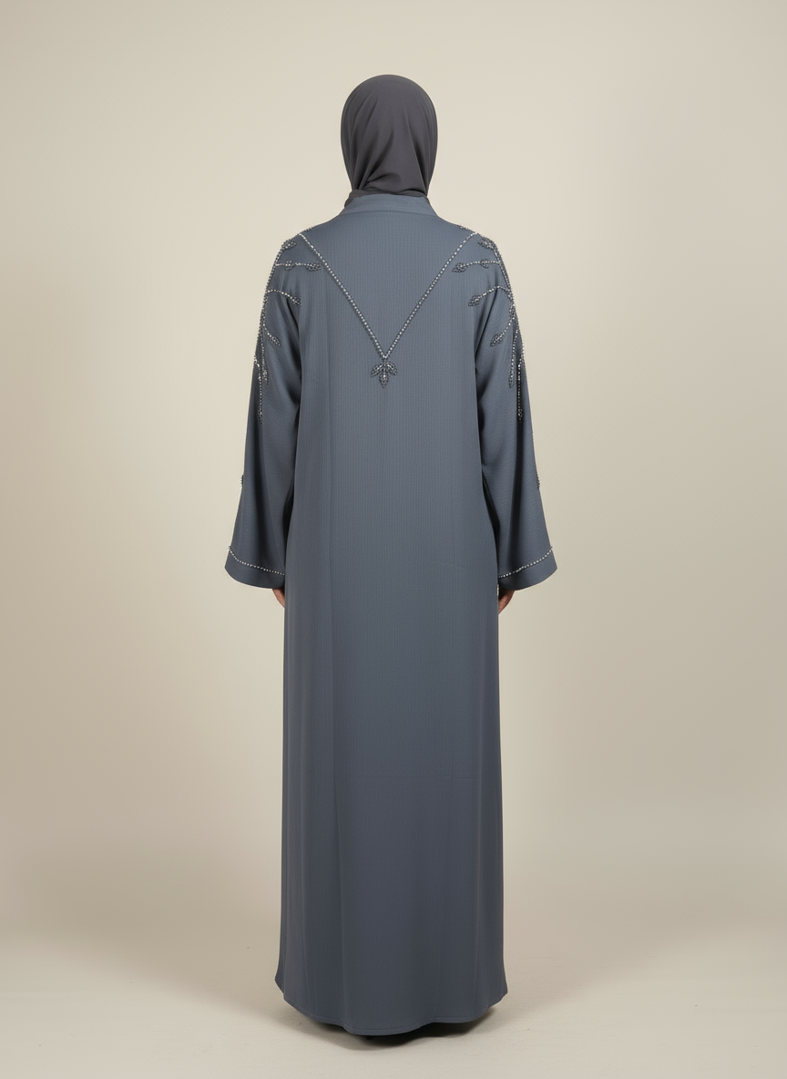 Person wearing a long, dark blue abaya with a matching hijab on a beige background