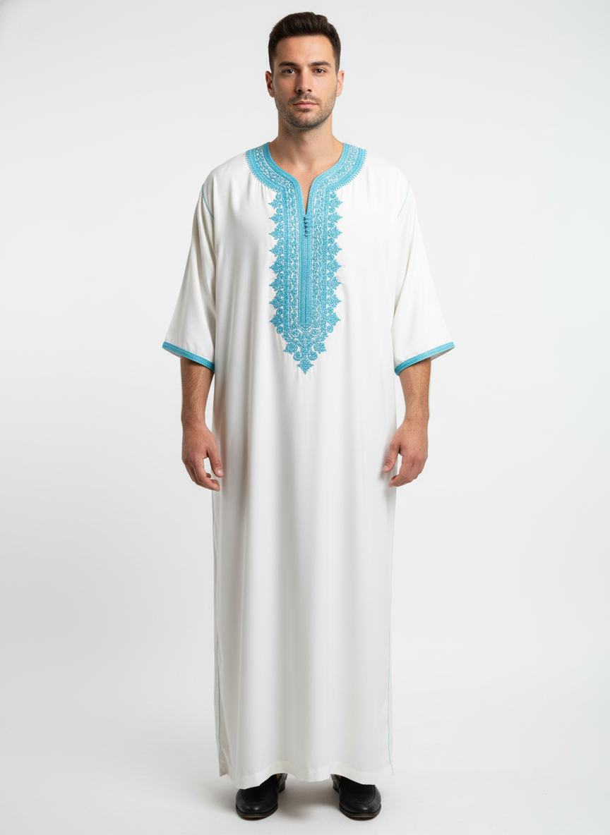 White Moroccan Gandoura with detailedlight blue embroidery and centralbuttons showcasing refined craftsmanship.”