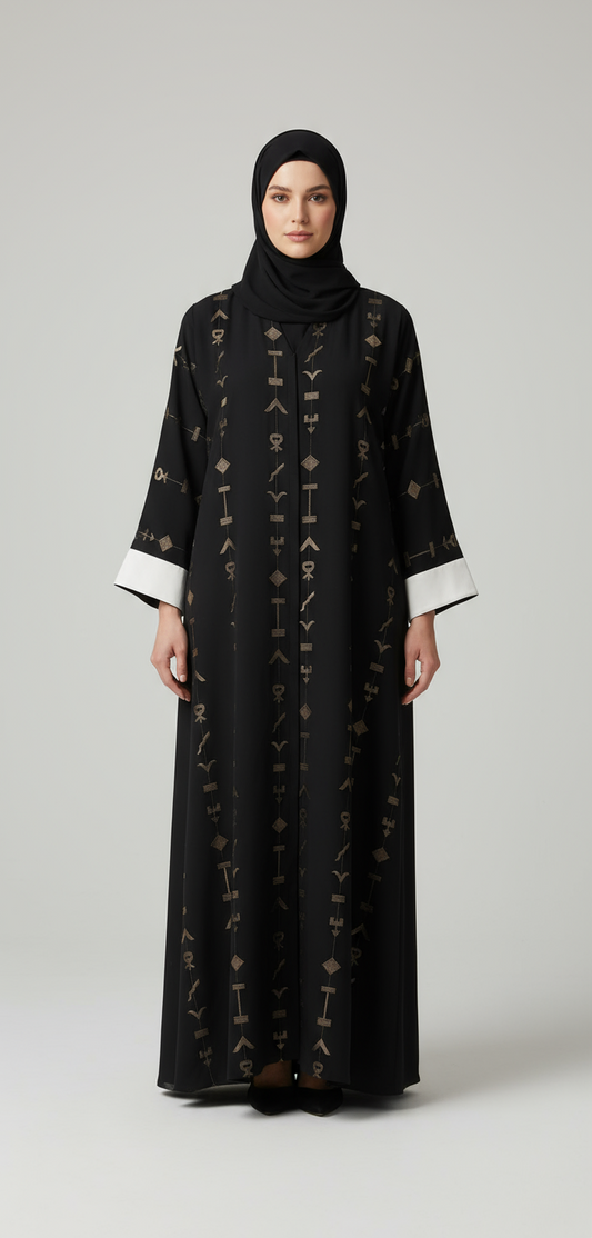 Woman wearing a black abaya with intricate patterns on a white background