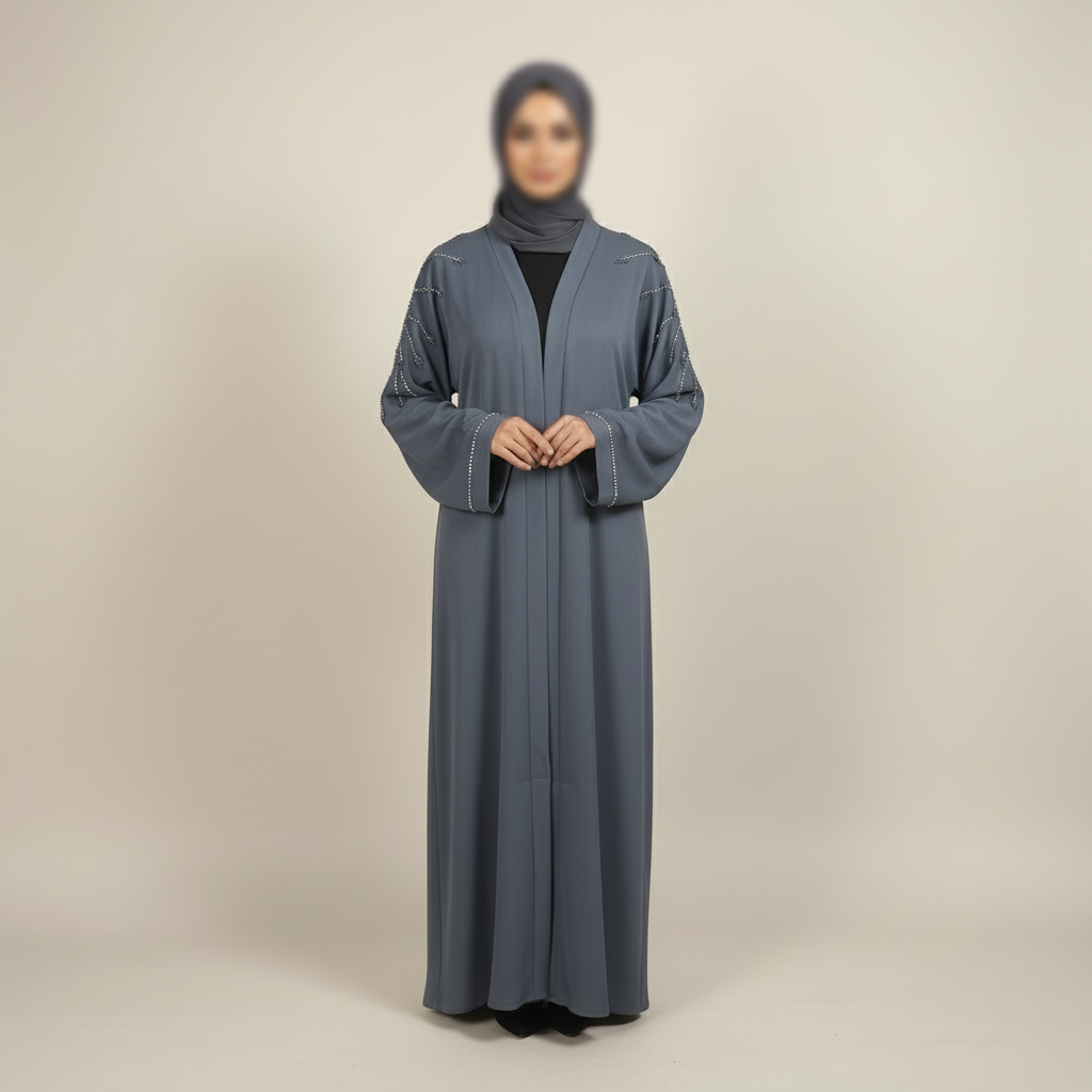 Woman wearing a long, dark gray abaya with a matching hijab on a beige background